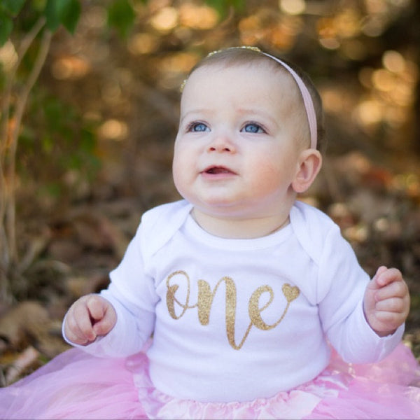 baby wearing glitter old gold onesie